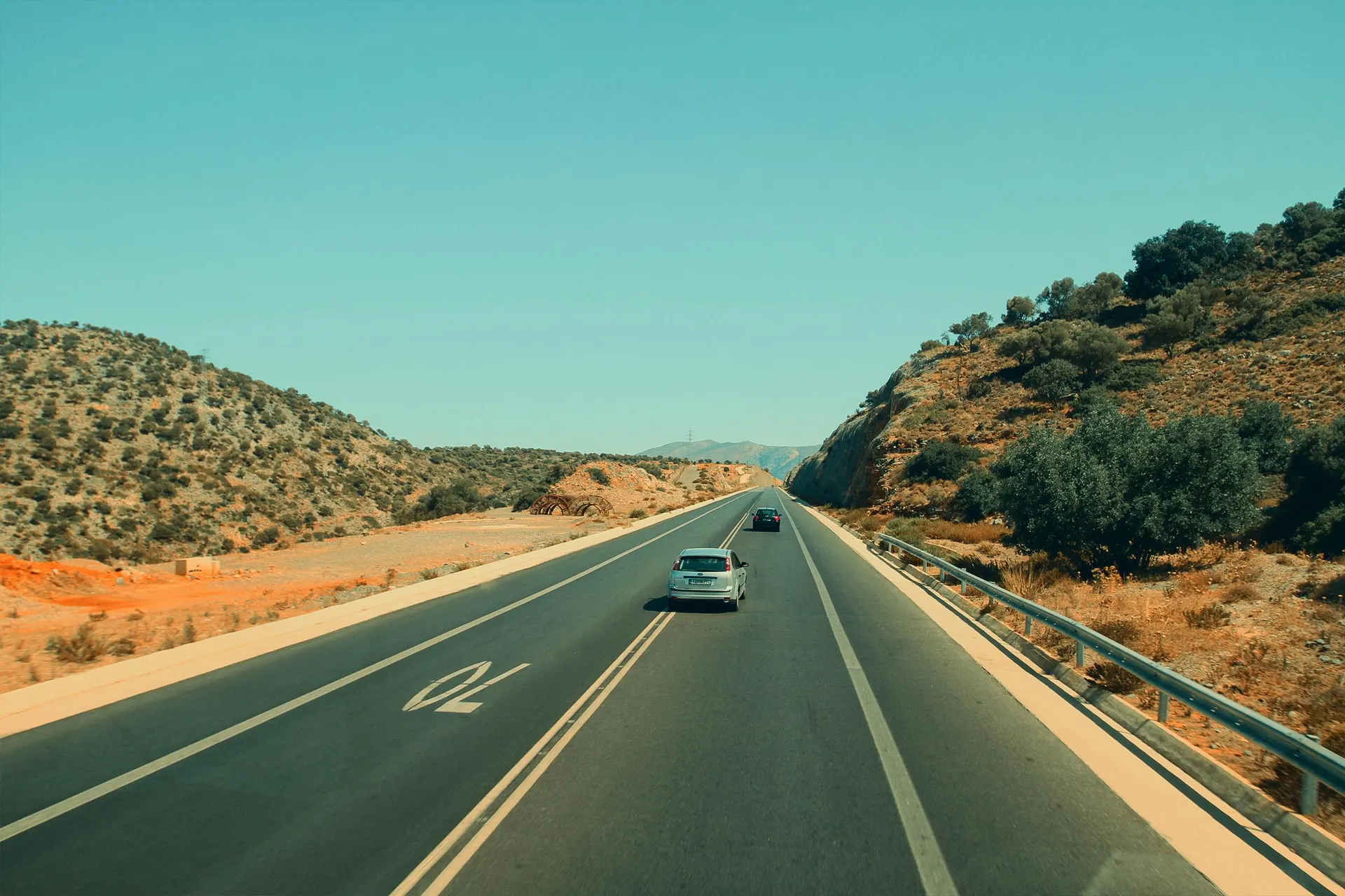 Carretera amplia hacia una ciudad histórica española al atardecer